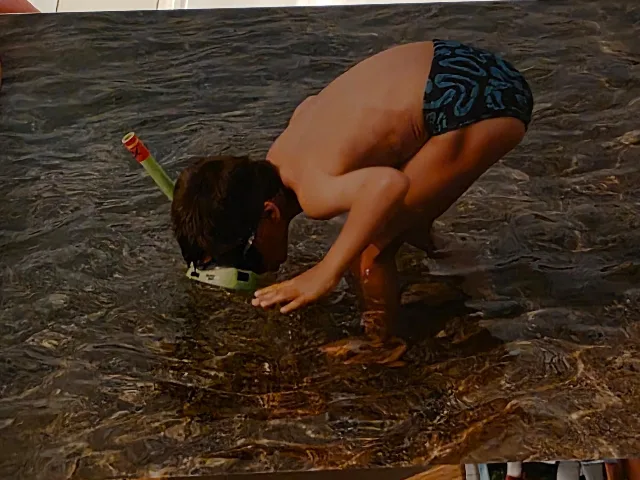 Me as a kid, snorkelling face-down in knee-deep water