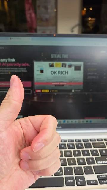A thumbs-up in front of a laptop showing the OK RICH page.